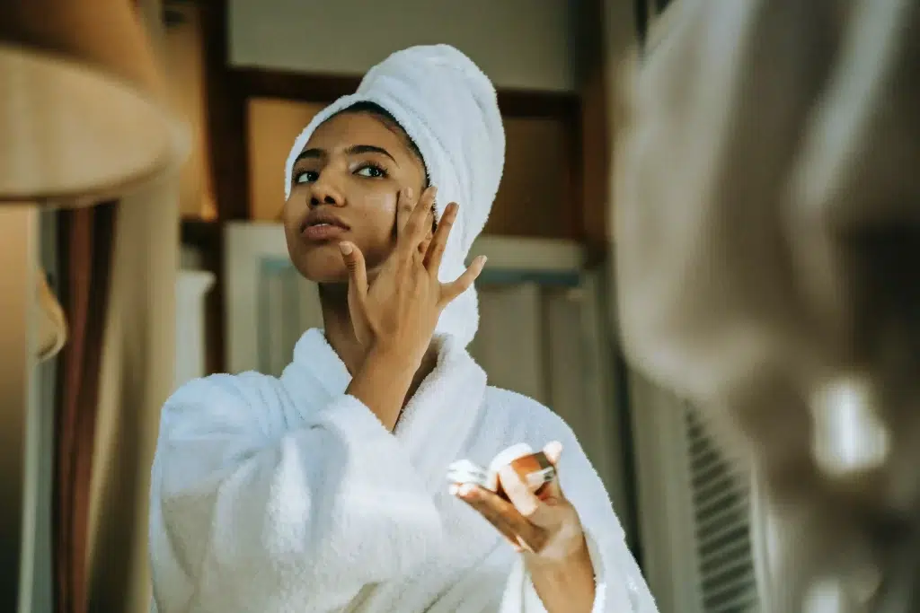 Woman applying SPF as the final step of her morning skincare routine