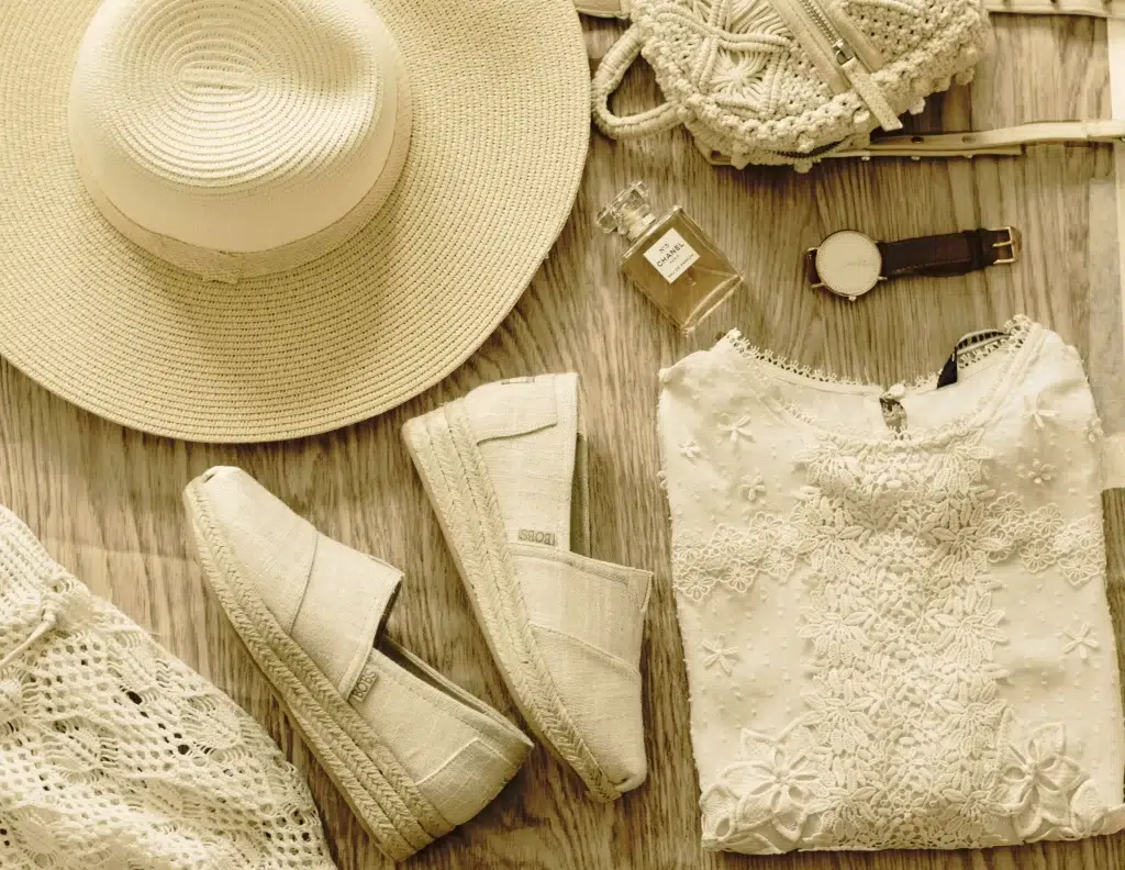 Summer Capsule Wardrobe Over 50: 15 Pieces That Work All Season 2 Summer capsule wardrobe over 50 - 15 essential pieces laid flat including linen trousers, wrap dress, and denim jacket