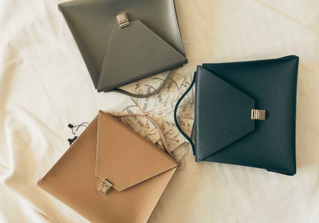 Flat lay of the best handbag colors for fashion-forward looks including cream, navy, grey and beige