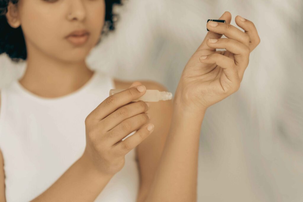 Applying a cruelty free eau de parfum rollerball to the wrist