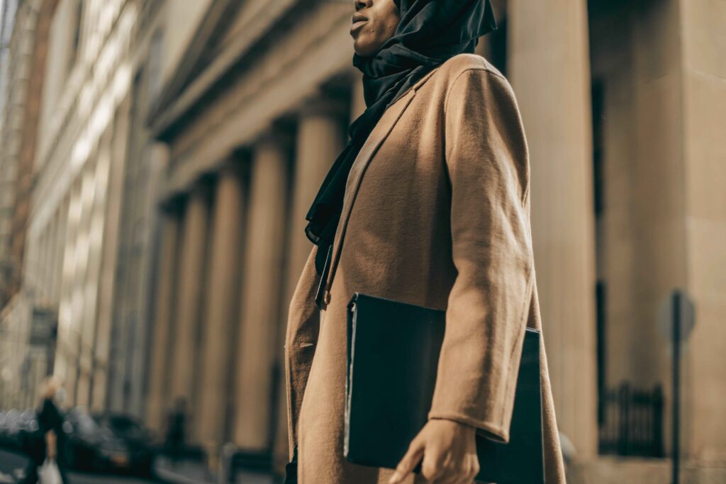 Deep navy handbag styled with a camel coat for a fashion-forward outfit