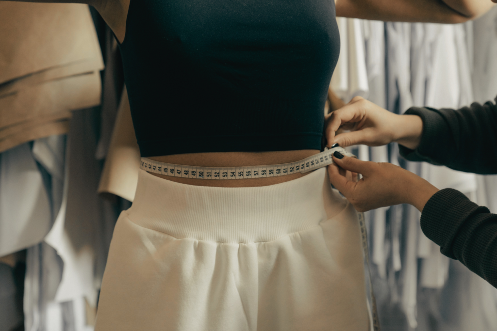 7 Easel Dress and Pants Styles Worth Adding to Your Closet 3 Woman checking the fit of Easel pants for women in a boutique fitting room