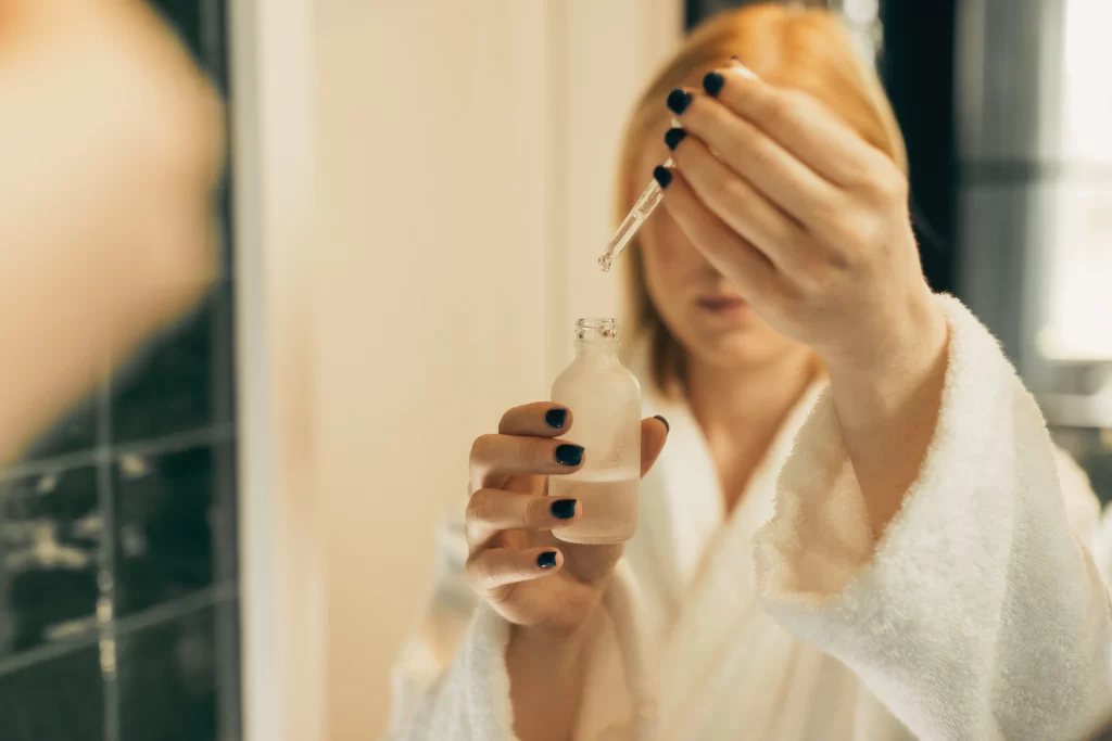 applying a cruelty-free skincare serum with a dropper bottle as part of a daily routine