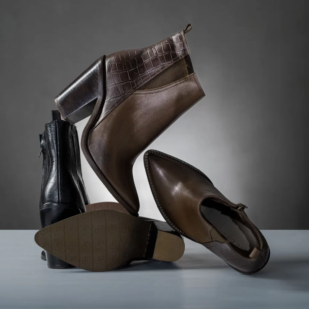 Office Boots for Women: 10 Pairs That Mean Business 1 Flat lay of office boots for women including chelsea, knee high, and block heel styles
