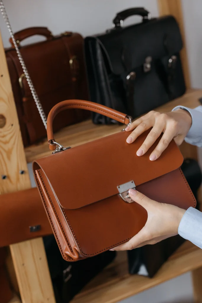 Where to Sell Your Designer Bags: 7 Platforms Compared 3 pawn shop employee inspecting a designer bag before making an offer