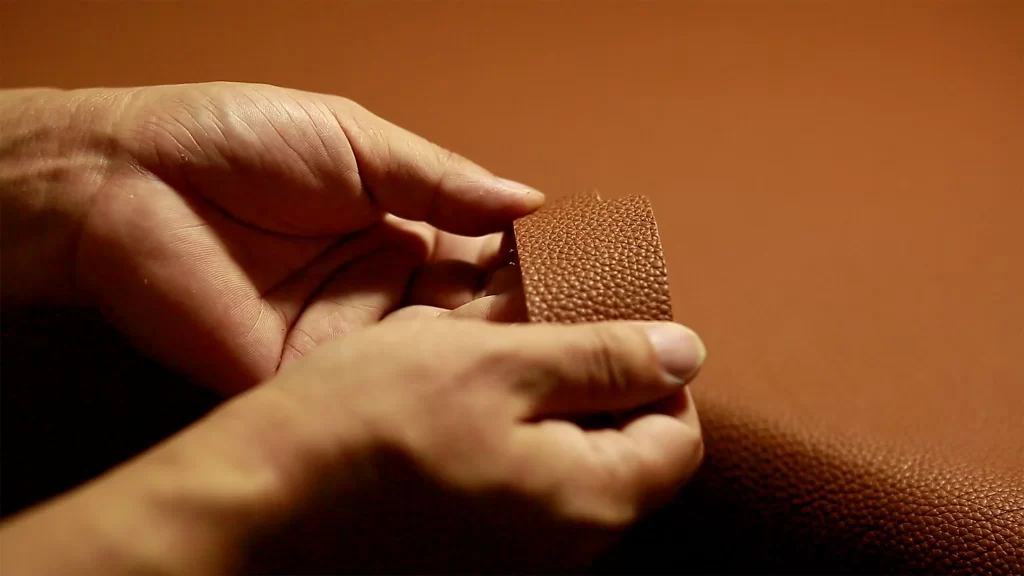 Real vs Fake Leather Bag: How to Tell If It's Real 1 hands performing a texture test to check if a leather bag is real or fake