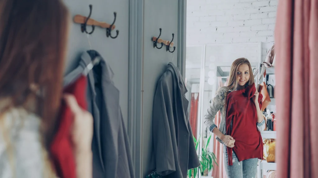 Boutiques Like Altar'd State: 7 Similar Style Picks 2 Shopper holding a satin midi dress in a fitting room while comparing affordable alternatives to Altar'd State