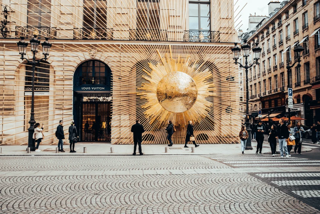 Goyard vs Louis Vuitton: Which One Is Worth the Money? 4 Shopper entering a Paris luxury boutique to buy a designer tote in person