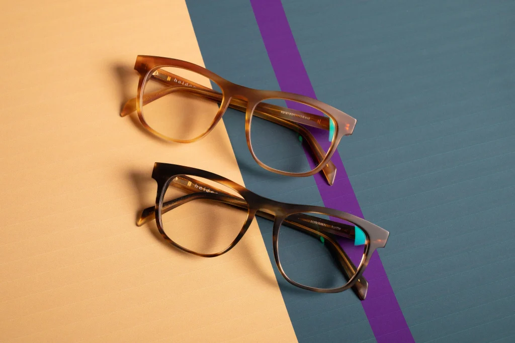 Quay vs Ray-Ban: Which Sunglasses Are Worth the Money? 1 Quay vs Ray Ban sunglasses side by side, an oversized tortoiseshell Quay frame next to a black Ray Ban Wayfarer